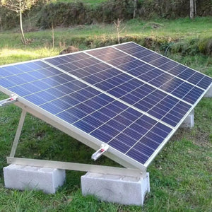 Solar panel mounting kit installed on grass, showing aluminum frame with concrete block supports and angled panel array.