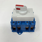 Kraus & Naimer 63A manual changeover switch with white actuator head and red handles mounted on blue terminal block base, lab