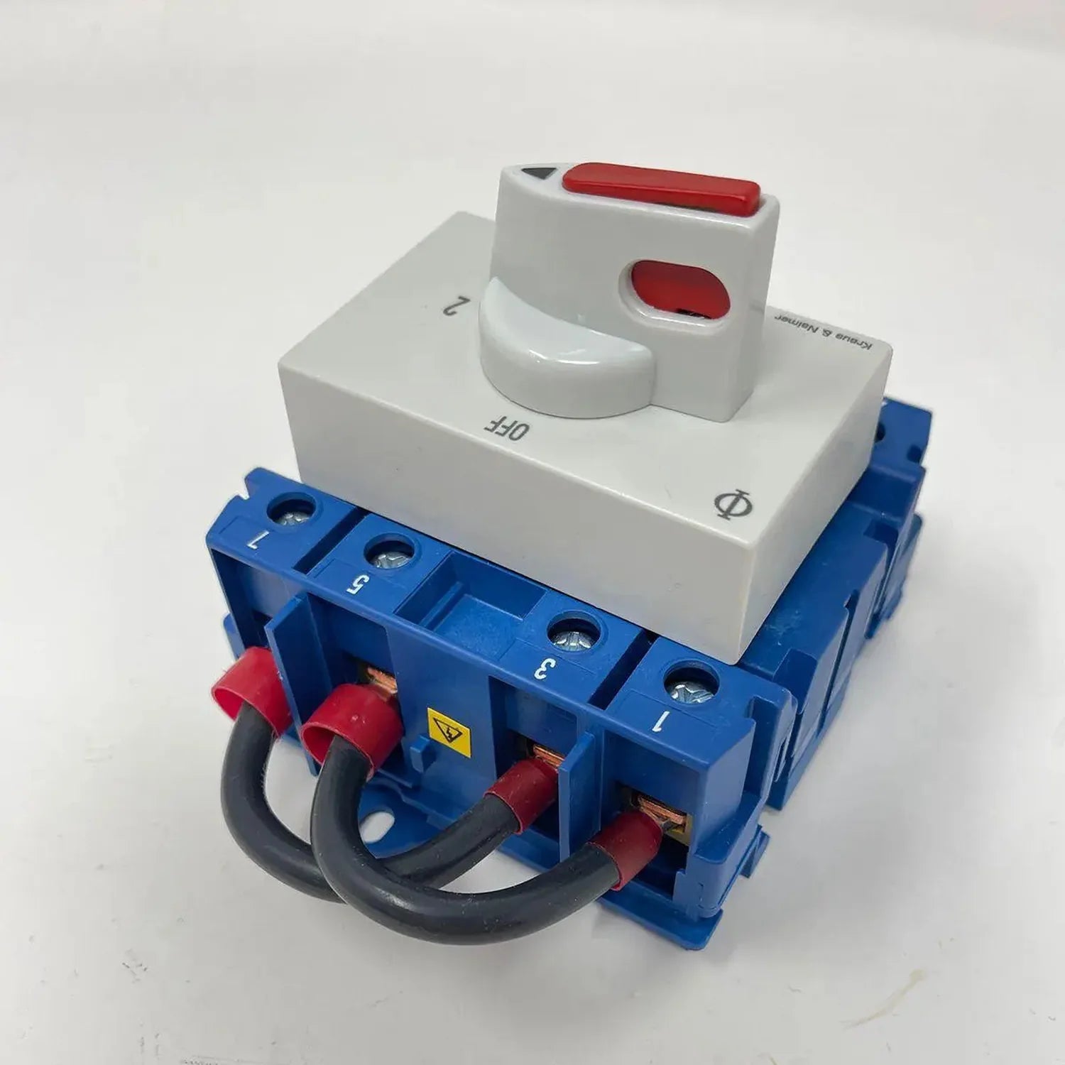 White 2-pole changeover switch with red handles mounted on blue terminal block with red and black wires attached.