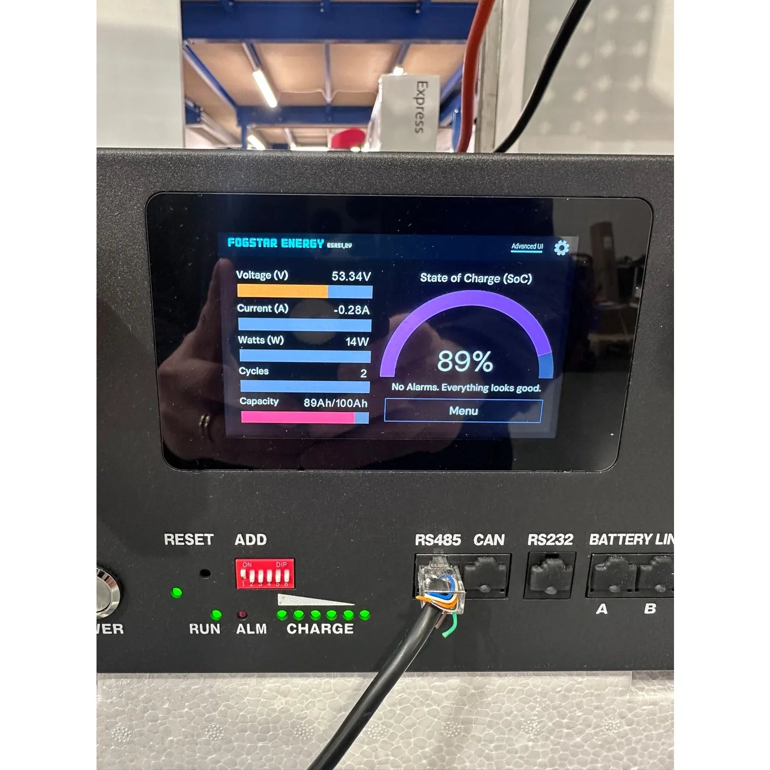 FogStar Energy battery management display screen showing 53.34V voltage, 89% state of charge, and 14W power output with syste