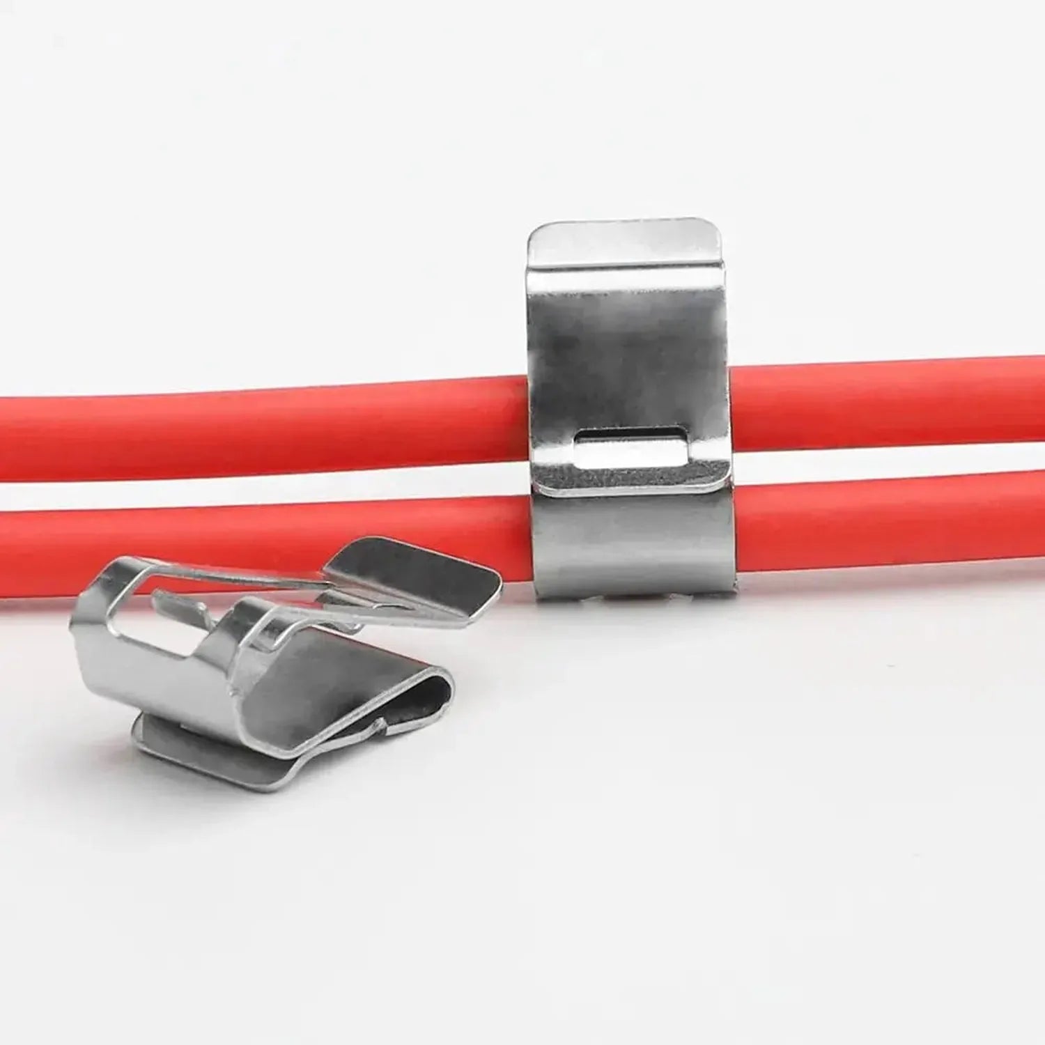 Stainless steel solar panel cable clips securing red cables, showing one attached and one detached unit on white background.