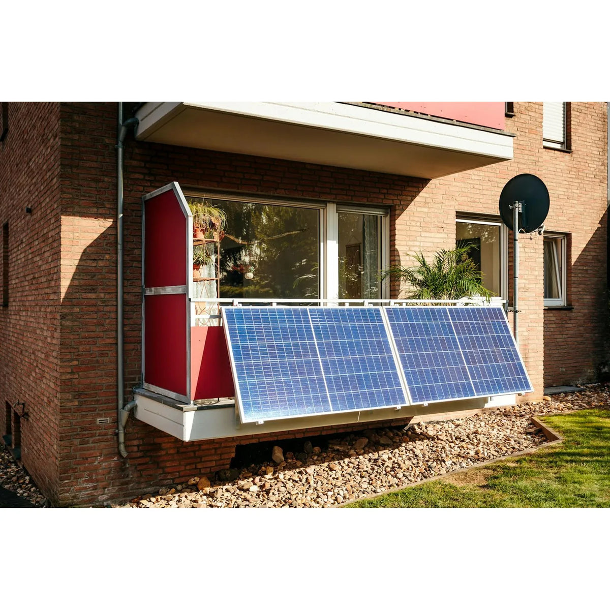 Solar panel kit installed on residential brick building exterior, showing two blue bifacial panels mounted on white frame wit