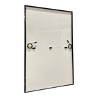 Solar panel front view showing white surface with black frame and three mounting brackets with cables attached.