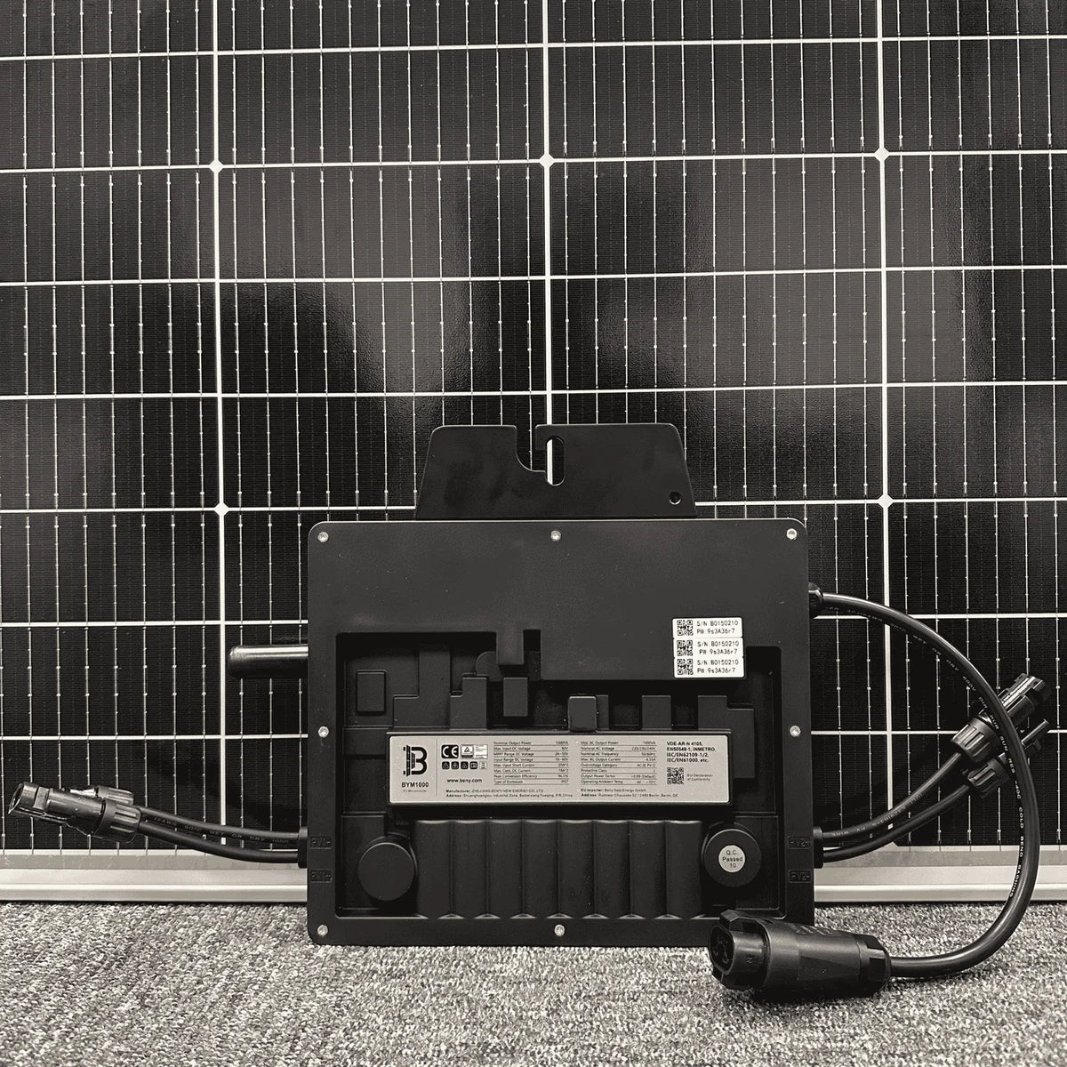 Solar micro inverter mounted on photovoltaic panel with AC and DC cables attached, showing product label and certification ma