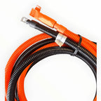 Coiled orange and black battery extension cable with connectors at one end and a white label band, displayed against white ba