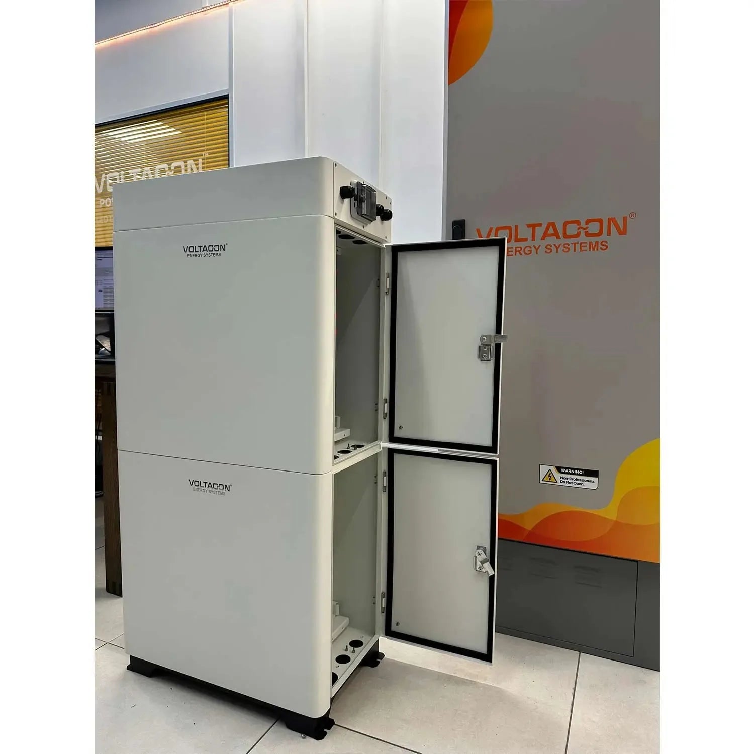 Voltacon energy storage cabinet with open door displaying internal battery compartment at trade show display.