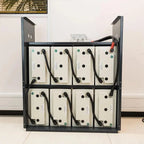 Black metal rack mounted with eight cream-colored battery units arranged in two rows, each with black cables and connectors, 