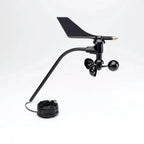 Black wind turbine generator with vane and rotor cups, coiled cable attached, displayed against white background.