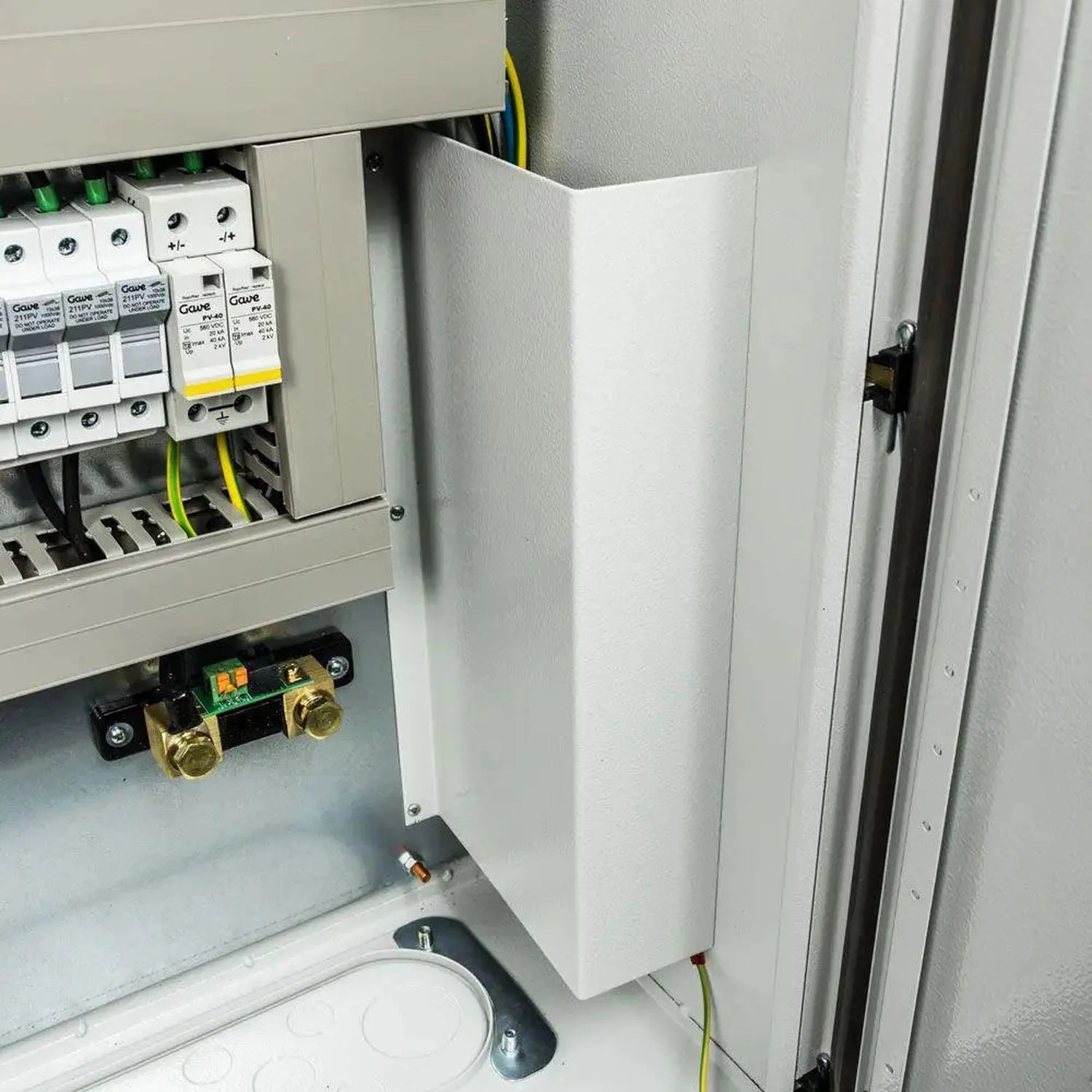 White cabinet installation shot showing circuit breakers, wiring, and internal components mounted in electrical enclosure.