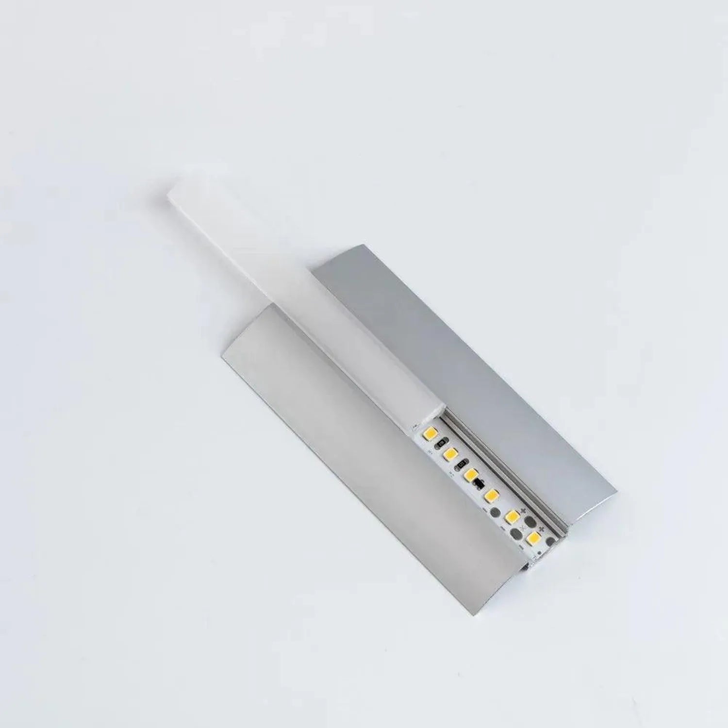 Silver aluminium LED profile with frosted diffuser and visible yellow LED strip inside, angled view on white background.