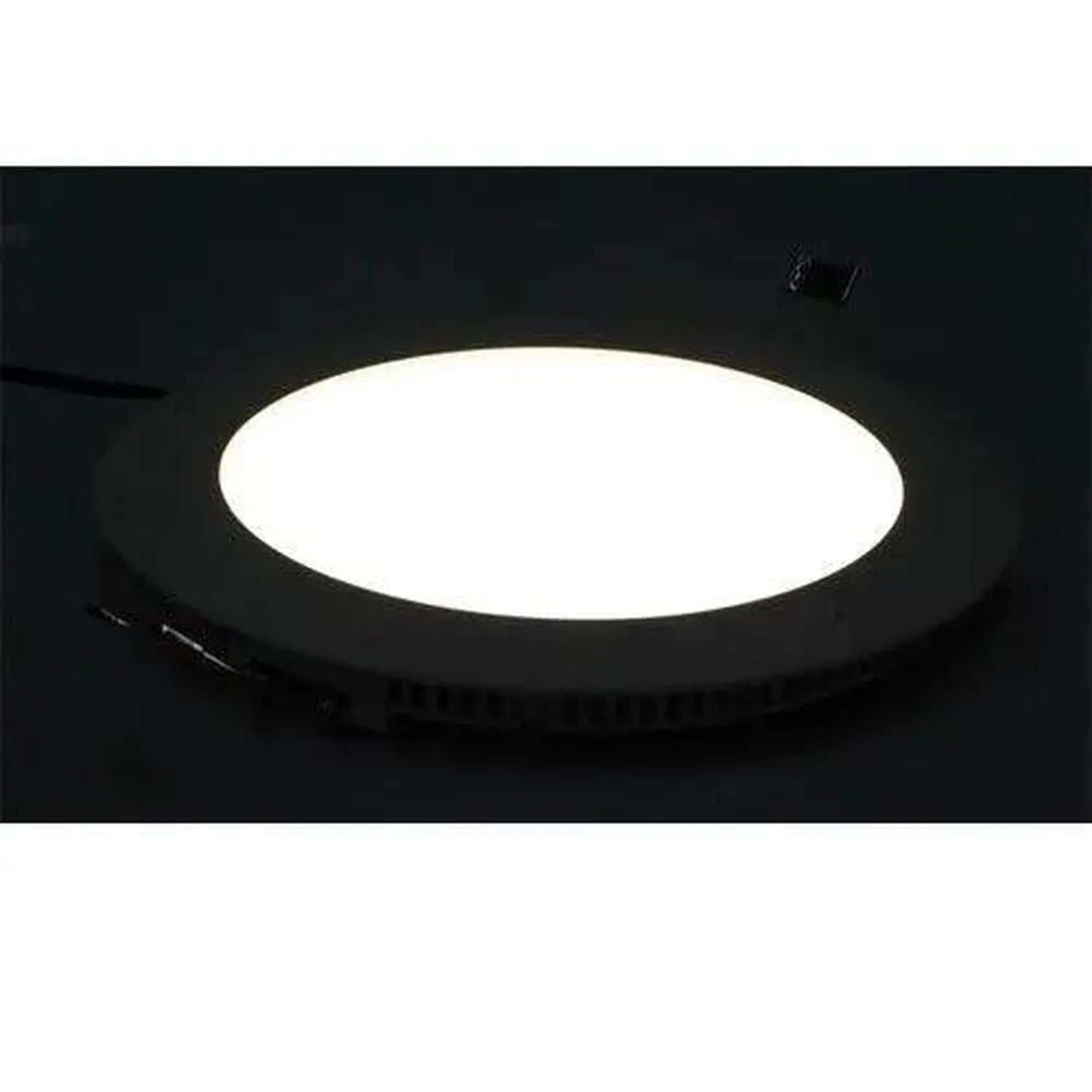 Round LED recessed ceiling light with bright white center panel and black trim ring, installed in dark ceiling, shown in inst