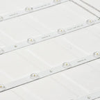 Multiple LED backlit panel light strips arranged in rows, showing individual lens units with brass connectors on white backin
