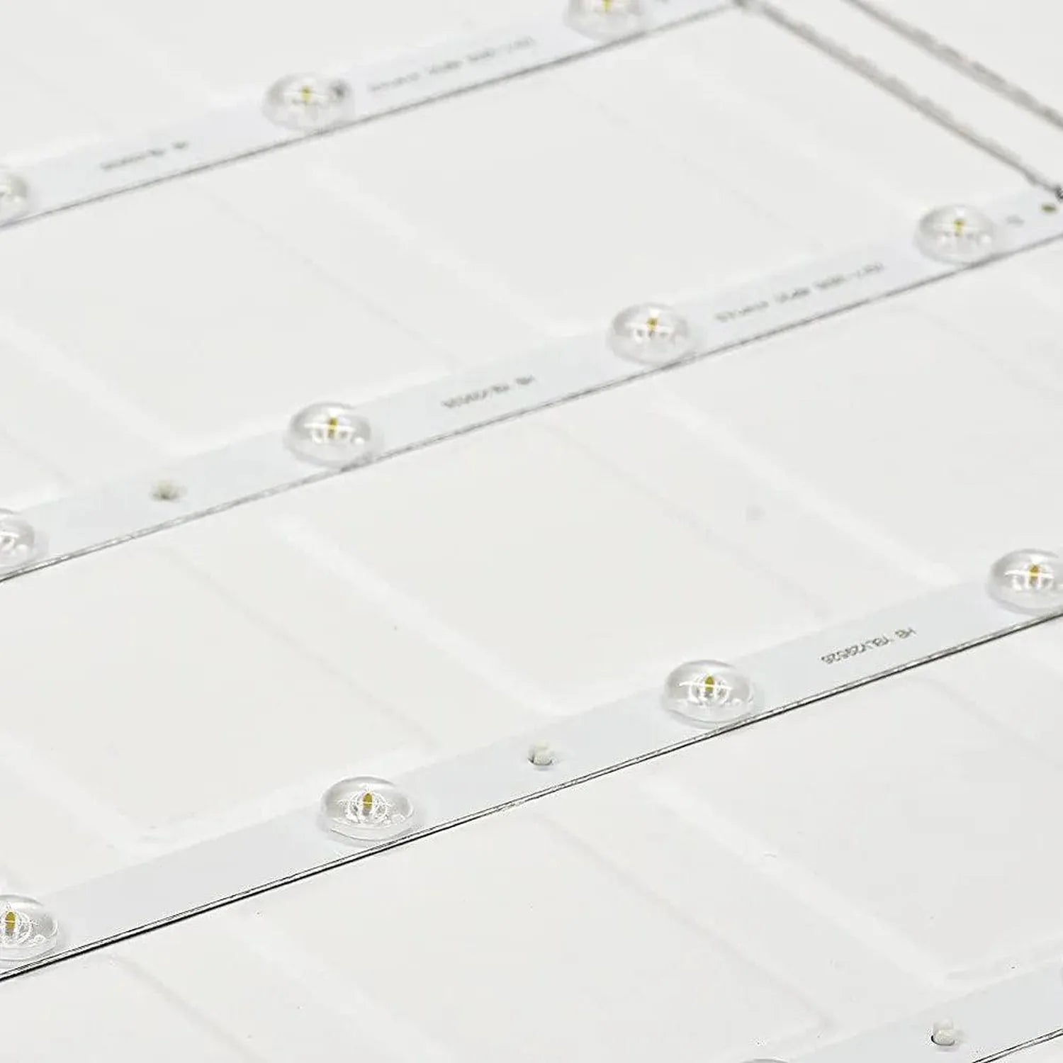 Multiple LED backlit panel light strips arranged in rows, showing individual lens units with brass connectors on white backin