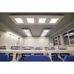 Recessed LED panel lights installed in modern classroom ceiling with blue chairs visible below