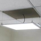 Modern LED panel suspended from ceiling with cable kit installed, showing bright white illumination and metal mounting hardwa