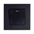 Black 1-gang 2-way light switch with illuminated indicator, shown mounted on dark square wall plate.
