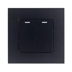 Black dual-gang 2-way light switch with illuminated indicators on each toggle, mounted on square faceplate.