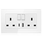 White wall-mounted electrical outlet plate with two toggle switches, two USB ports, and four rectangular sockets on tempered 