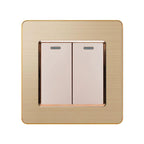 Gold 2-gang 2-way light switch with cream-colored buttons and bronze trim on brushed gold plate