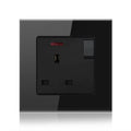Black tempered glass 1-gang switched socket outlet with red indicator light and toggle switch, mounted on wall plate.