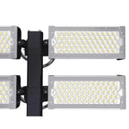 LED flood light fixture mounted on black pole showing four rectangular light panels with multiple LED elements arranged in gr