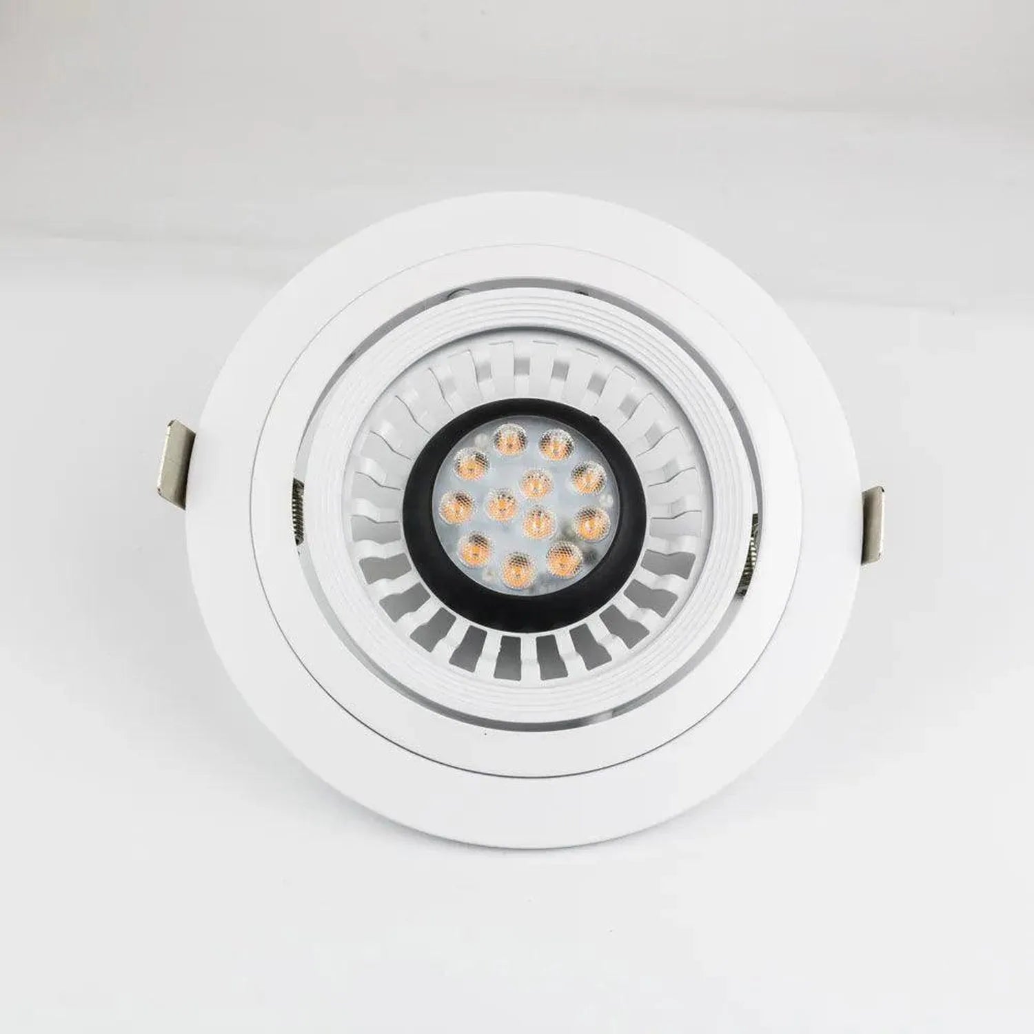 White round gimbal recessed light housing with black inner ring and warm LED bulb visible, shown against white background.