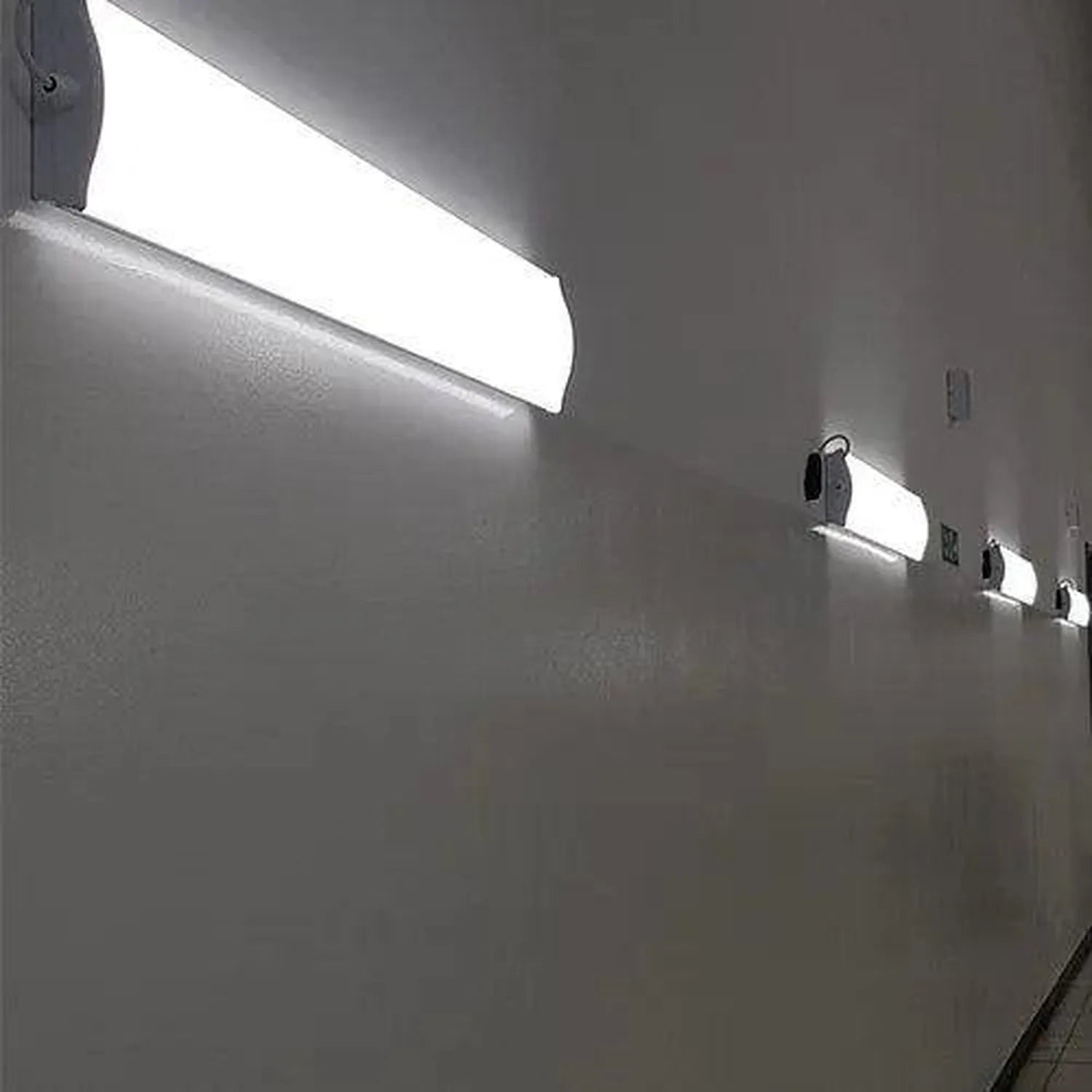 LED ceiling light installation shot showing one large rectangular fixture mounted above and three smaller matching fixtures o
