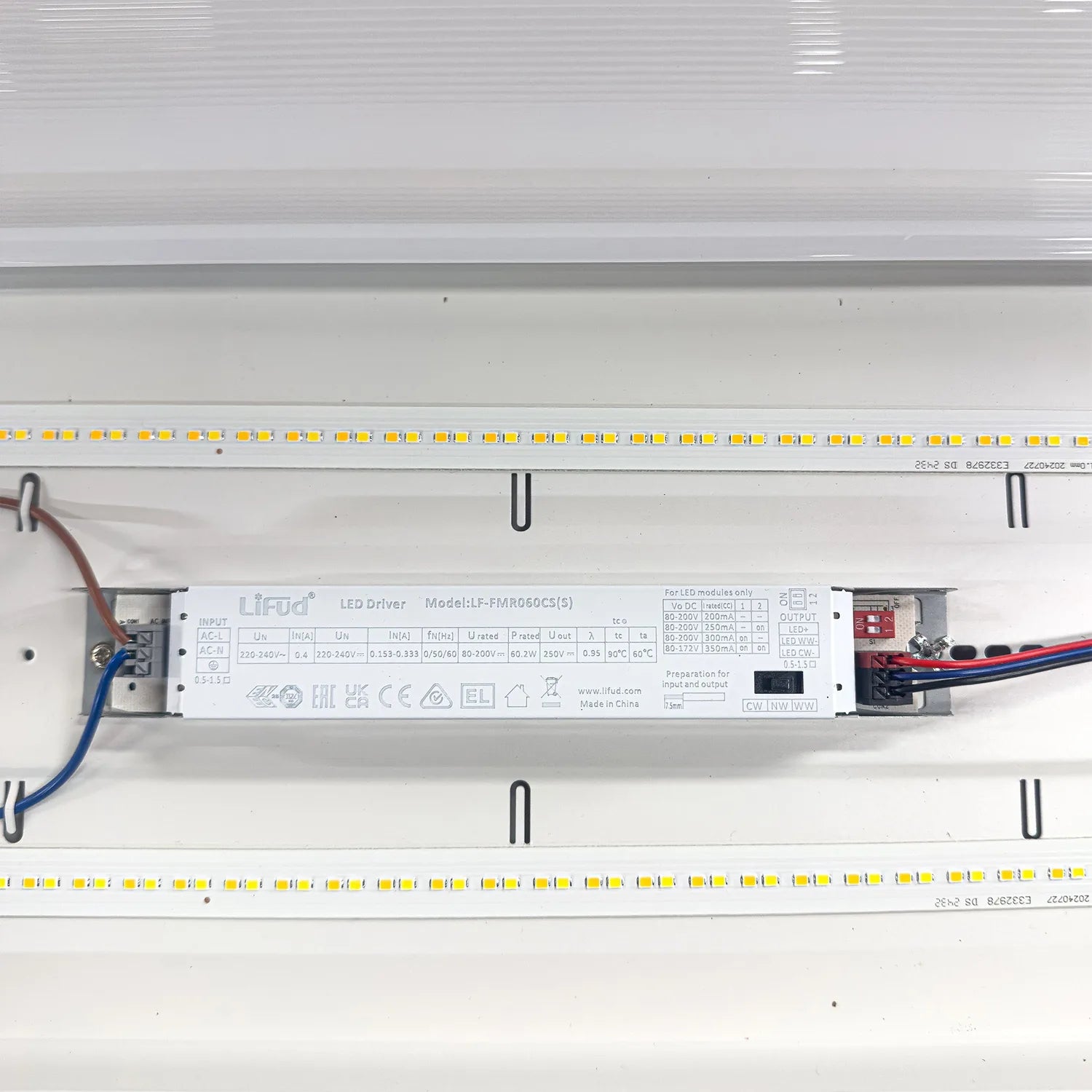 LED driver installation shot showing Lifud model HF-FMR060C5(S) mounted between two LED light strips with wiring connections 