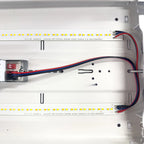 Installation shot of LED ceiling light interior showing dual LED strips with yellow diodes, power supply unit, and red and bl