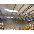 Industrial warehouse ceiling with LED high bay lights mounted on steel beam structure above storage racks.
