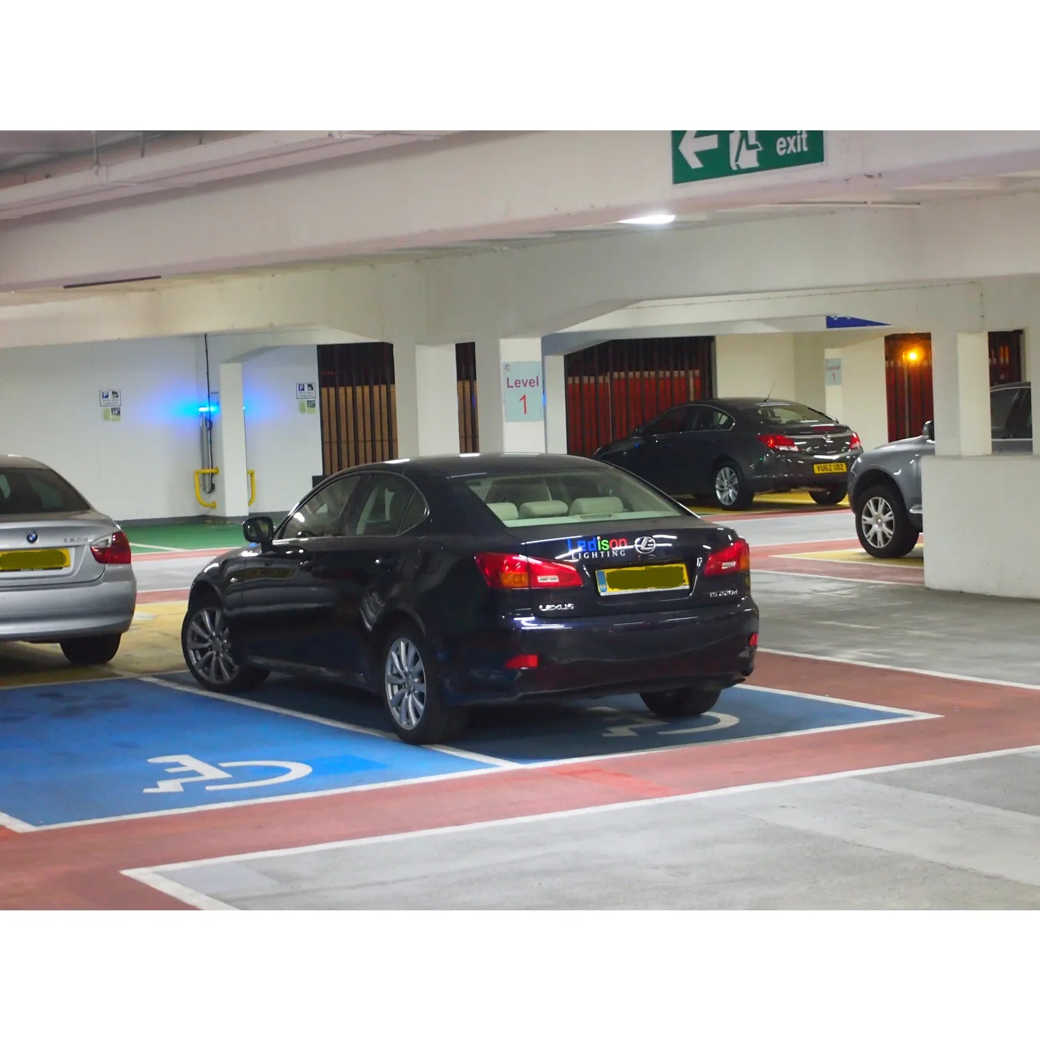 Underground parking garage Level 1 with parked cars and blue LED lighting strips on floor marking designated spaces