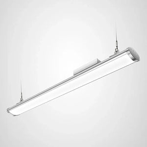 Linear LED high bay light fixture suspended from ceiling, silver aluminum housing with white diffuser panel, dual hanging cab