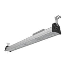 Linear LED high bay light fixture with aluminum body, diffuser lens, and black mounting brackets shown at an angle on white b
