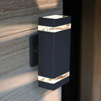 Black rectangular outdoor wall light with horizontal LED strips, mounted on wooden siding.