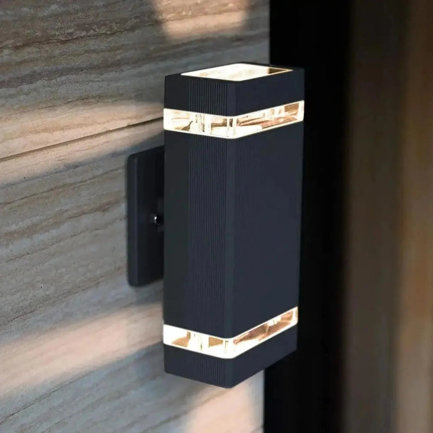 Black rectangular outdoor wall light with horizontal LED strips, mounted on wooden siding.