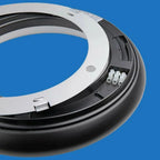 White and black circular LED ceiling light fixture, underside view showing connector pins against blue background.