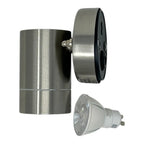 Disassembled LED outdoor downlight showing stainless steel cylindrical fixture body, black trim ring, and white GU10 LED bulb