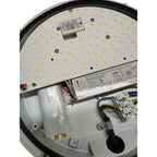 Interior view of LED ceiling fixture showing yellow LED array, electronic inverter module, capacitor, and wiring connections.