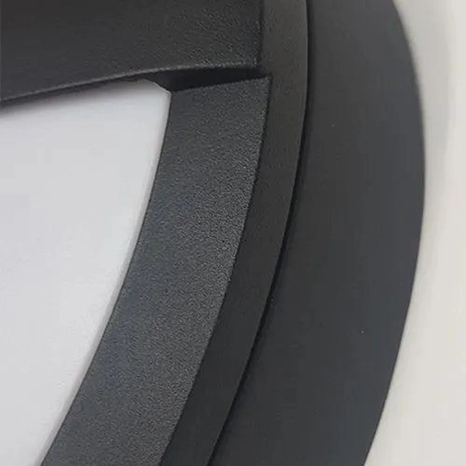 Close-up detail shot showing charcoal gray textured housing and white interior surface of outdoor wall light fixture.