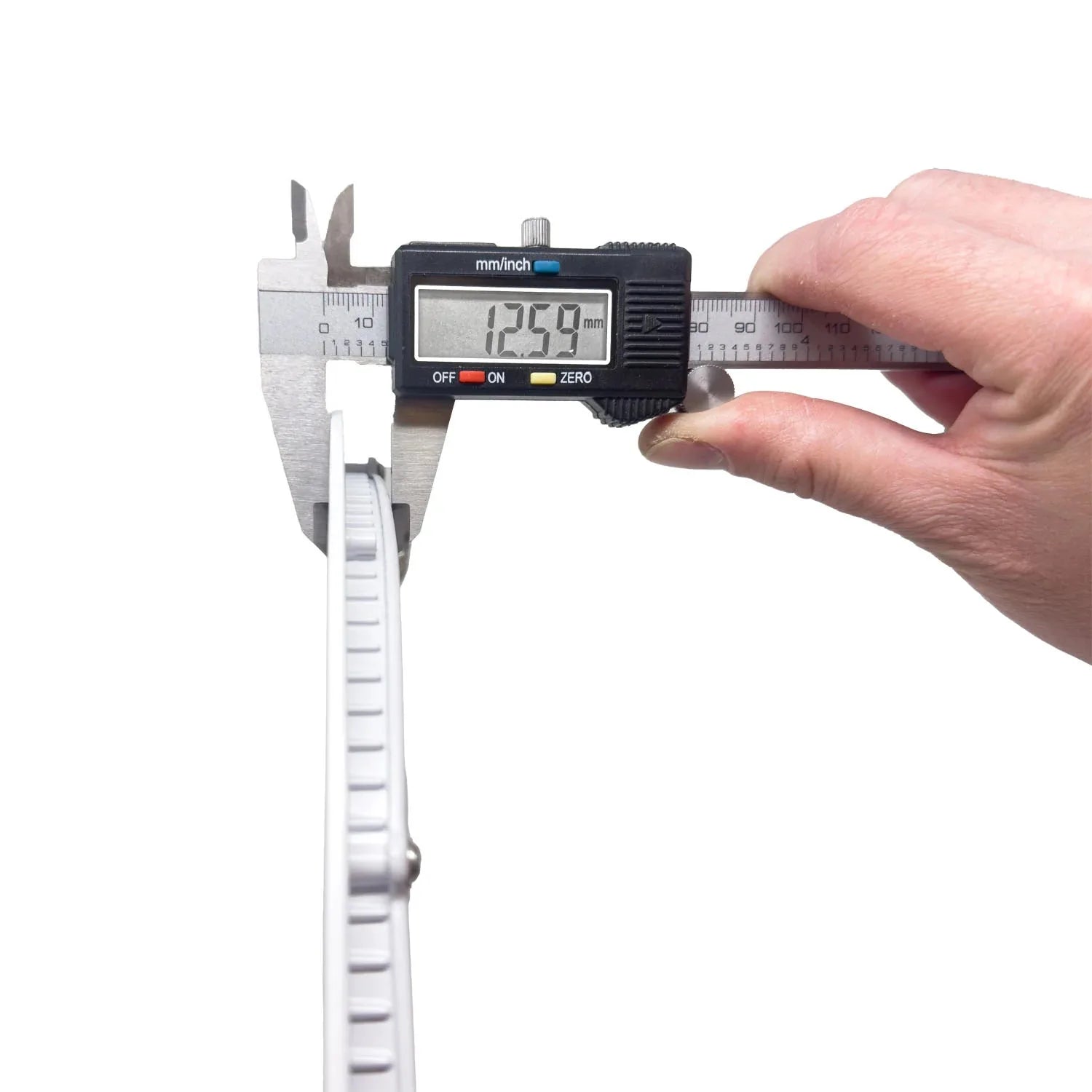 Digital caliper measuring a round white LED ceiling panel light, displaying 12.99 millimeters thickness.