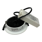 White LED downlight with black trim and power supply, showing specifications label and internal ribbed reflector design.