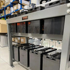 Voltagon 48V gel battery bank display with four units mounted on steel racks in warehouse setting, showing product labeling a