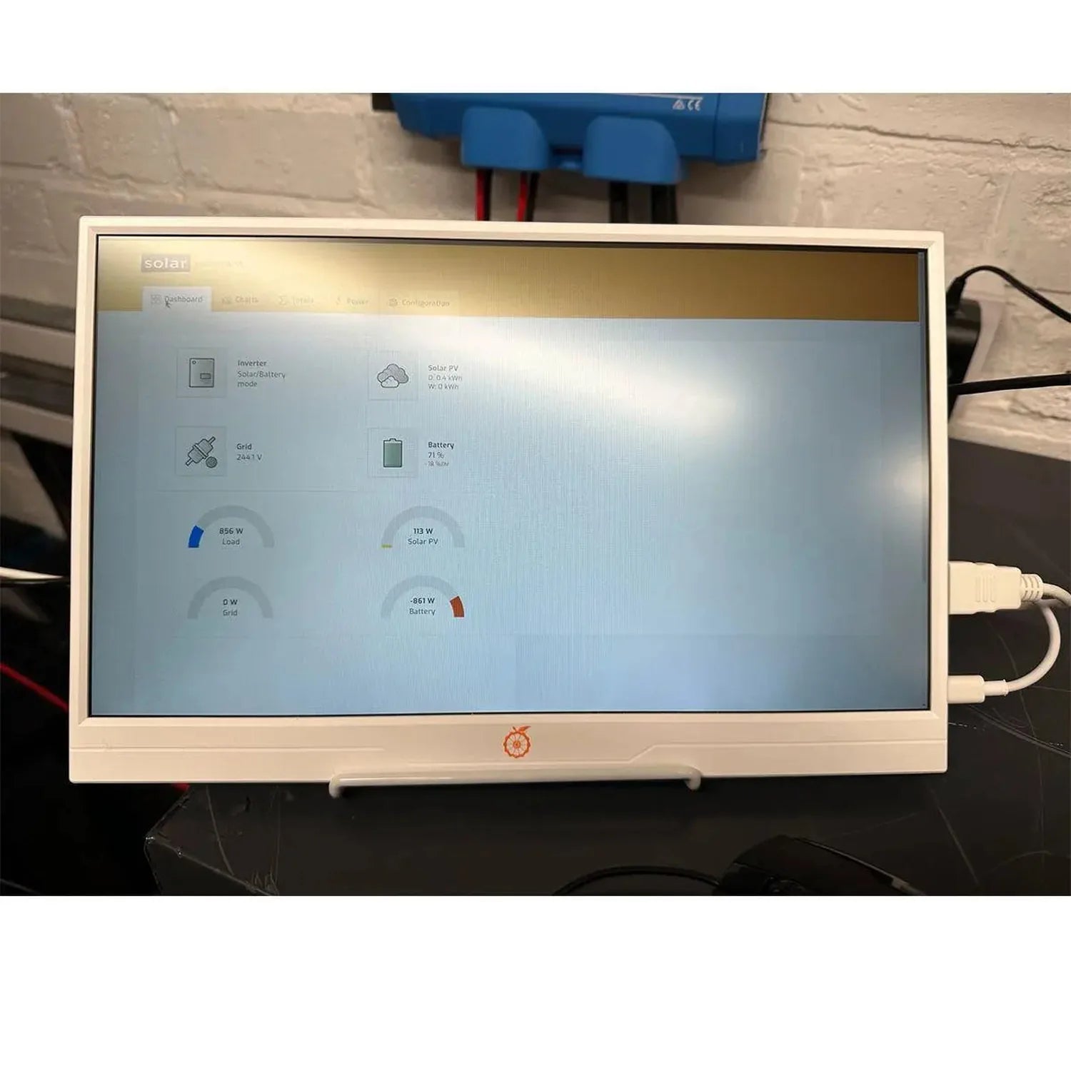 Solar energy monitoring display showing real-time dashboard with inverter, battery, grid, and solar PV power readings mounted