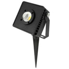 Black square LED flood light with single COB lens mounted on angled stake bracket, product shot on white background.