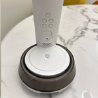 White OttLite LED desk lamp with wireless charging base and integrated clock display, shown on marble surface.