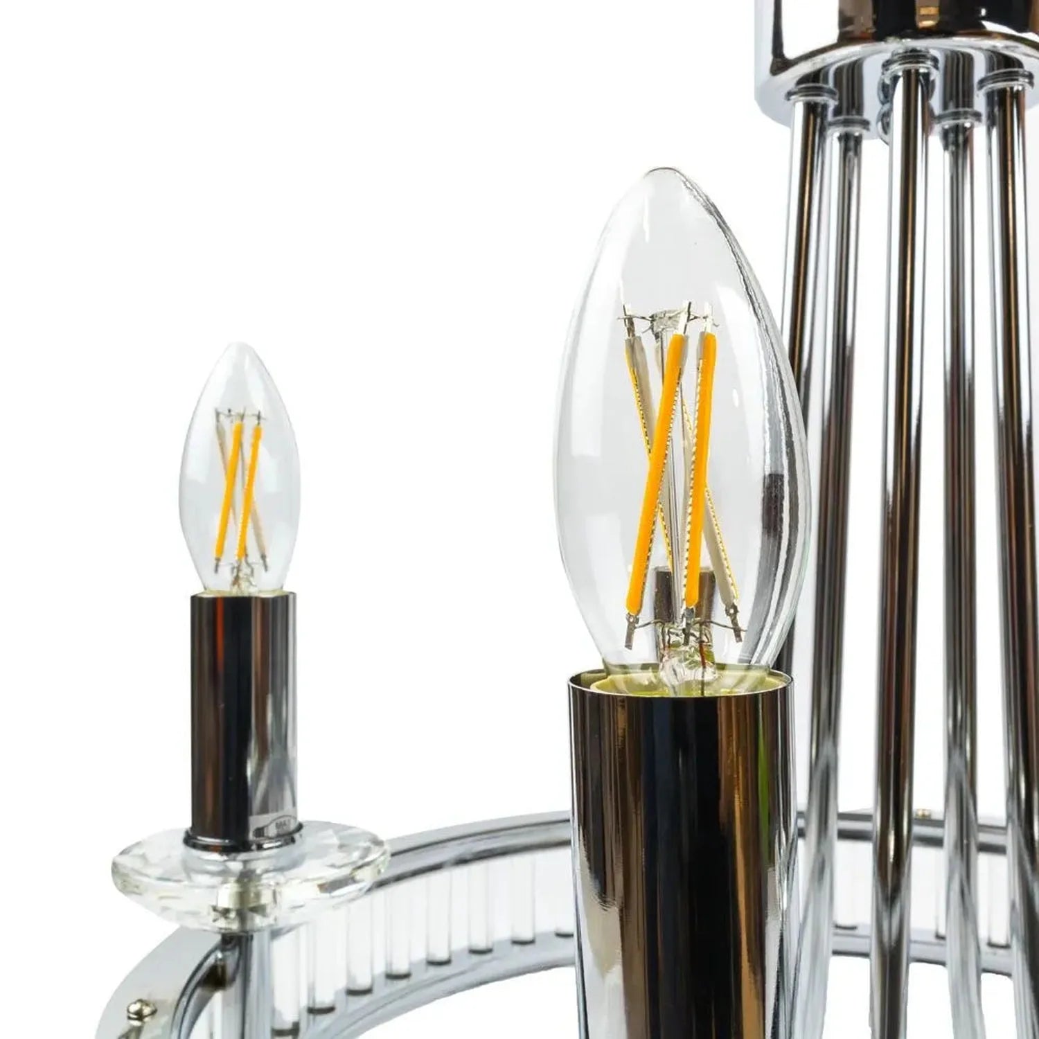 Two LED filament bulbs displayed next to a chrome chandelier fixture, showing warm yellow filaments inside clear glass candle