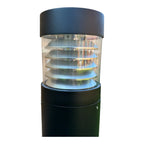 LED bollard light with dark cylindrical base, clear acrylic middle section showing five stacked shelves, and dark rounded top
