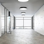 Modern office space with LunaRing surface mounted ceiling lights installed in linear array across white ceiling, illuminating