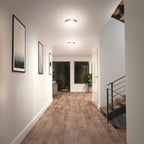 Artika Saturn flush mount LED ceiling light installed in modern hallway with white walls and wooden flooring
