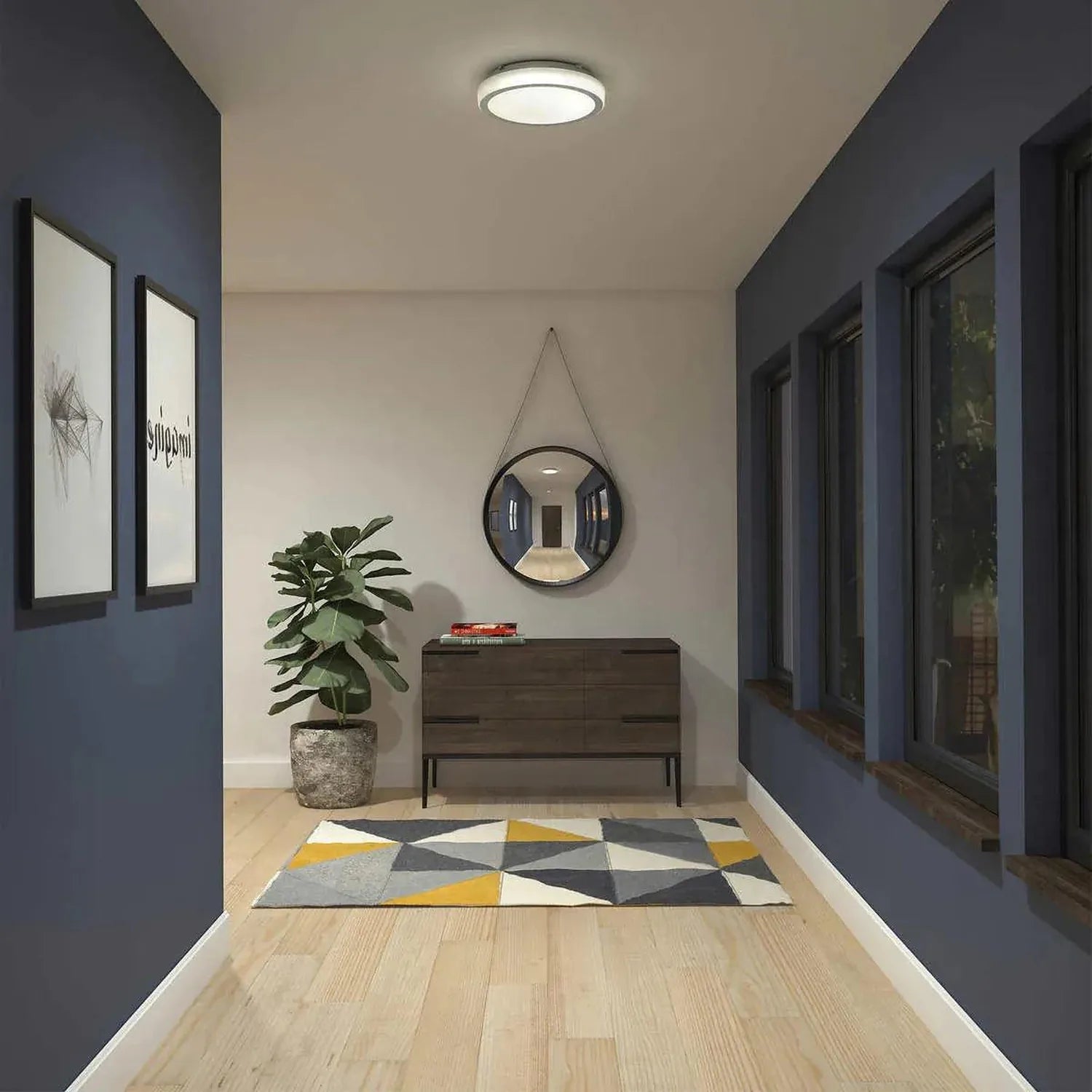 Artika Saturn flush mount LED ceiling light installed in modern entryway above dark wooden dresser with plant and round mirro
